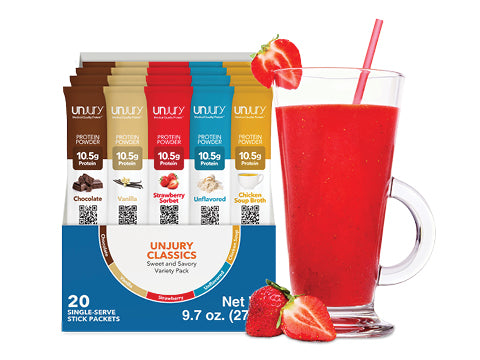 Unjury Classics protein powder stick packets with a glass of red smoothie and strawberries on a white background.